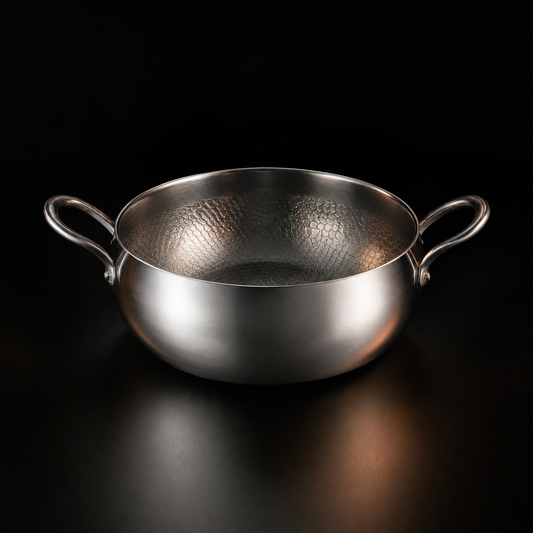 Hand-hammered deep titanium pot simmering a stew, PFAS-free cookware by Okura