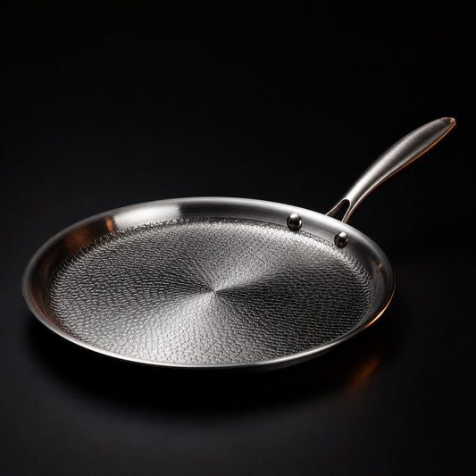 Hand-hammered flat titanium crêpe pan cooking a crêpe, PFAS-free cookware by Okura